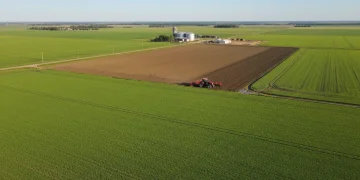 Vast agricultural field with tractor, symbolizing the 2026 Farm Bill's impact on production.